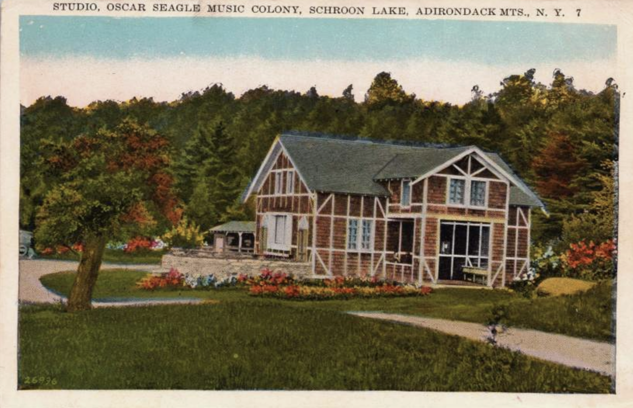 An antique color postcard showing the small studio at an early Adirondack music camp.